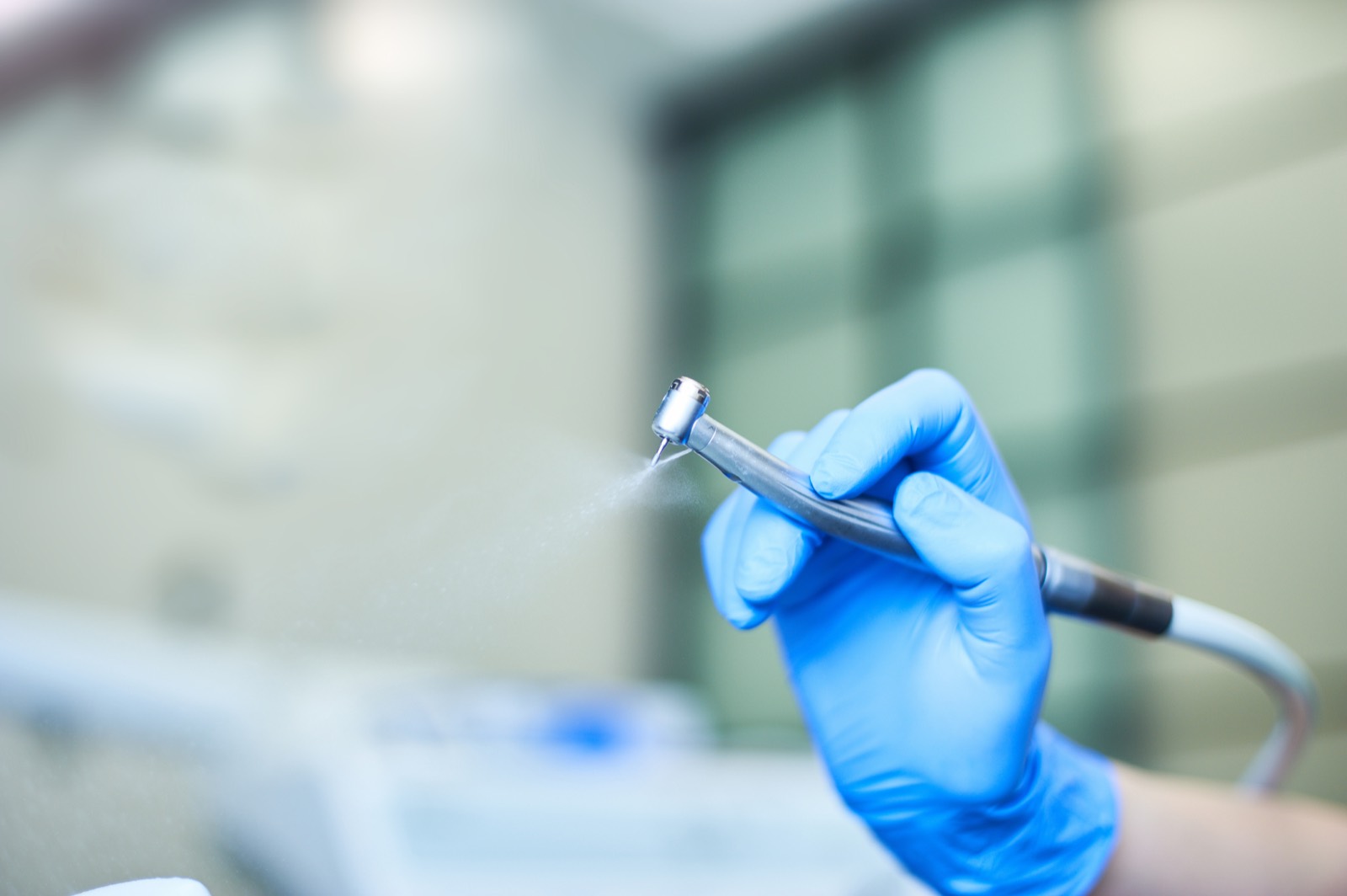 Dental handpiece in a clinician's gloved hand